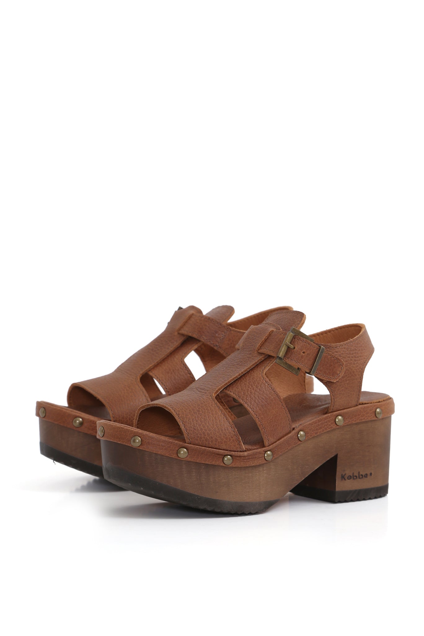 Modelo BUA Bali Texas Tostado de Kebba, sandalia tipo zueco en cuero liso tostado. Planta de madera nativa BUA de 8 cm y hebilla ajustable. Imagen lateral sobre fondo blanco. Piezas únicas en colecciones limitadas. Hecho a mano en Villarrica. Kebba: tradición y herencia en tus manos