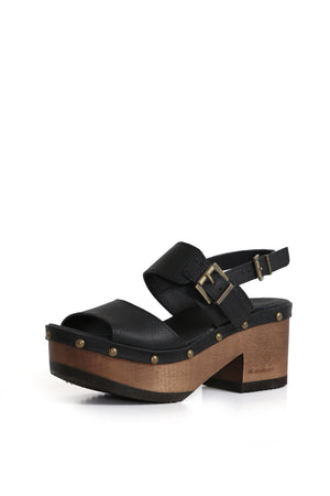 Sandalia artesanal BUA Etiopía Texas Negro. Cuero liso con doble hebilla y plataforma anatómica de 8 cm en madera tepa. Vista en tres cuartos sobre fondo blanco. Hecho a mano en Villarrica. Kebba: tradición y herencia en tus manos