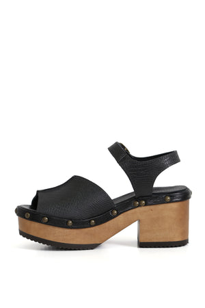 Zuecos artesanales negros estilo lezard sobre fondo blanco