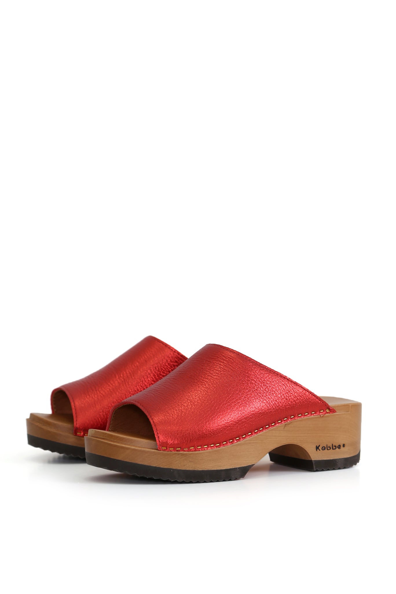 Zuecos artesanales Nicanor Floater Rojo, cuero floater liso color rojo metálico y planta de madera anatómica, vista lateral fondo blanco
