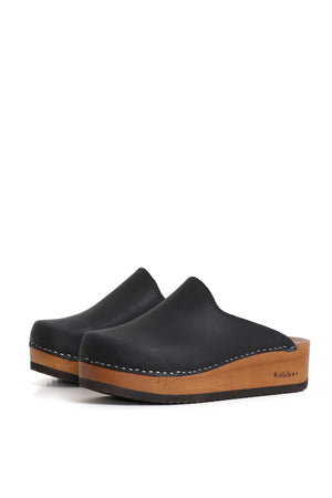 Zuecos artesanales Cloc West Negro, cuero graso negro sin forro y planta anatómica Kebba, vista lateral fondo blanco