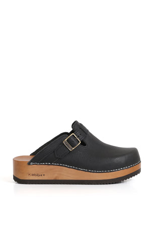 Zueco Kebba Riemen Texas Negro, cuero vacuno lustrable con grano visible. Modelo con ajuste de empeine y planta anatómica de madera Tepa de 5 cm. Imagen superior sobre fondo blanco. Piezas únicas en colecciones limitadas. Hecho a mano en Villarrica. Kebba: tradición y herencia en tus manos