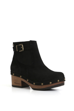 Fotografía de estudio de un botín negro de cuero artesanal. Énfasis en la calidad y el acabado del calzado hecho a mano en Chile.