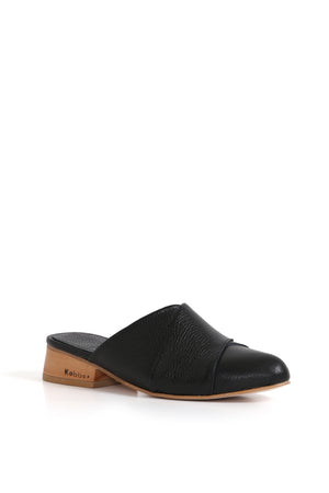 Alicante negro en uso, perfil caminando sobre fondo neutro; zapatos anatómicos.