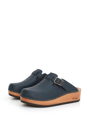 Zuecos artesanales Kebba Riemen azul náutico de cuero 2.2 mm sin forro con correa de ajuste, detalle frontal fondo blanco
