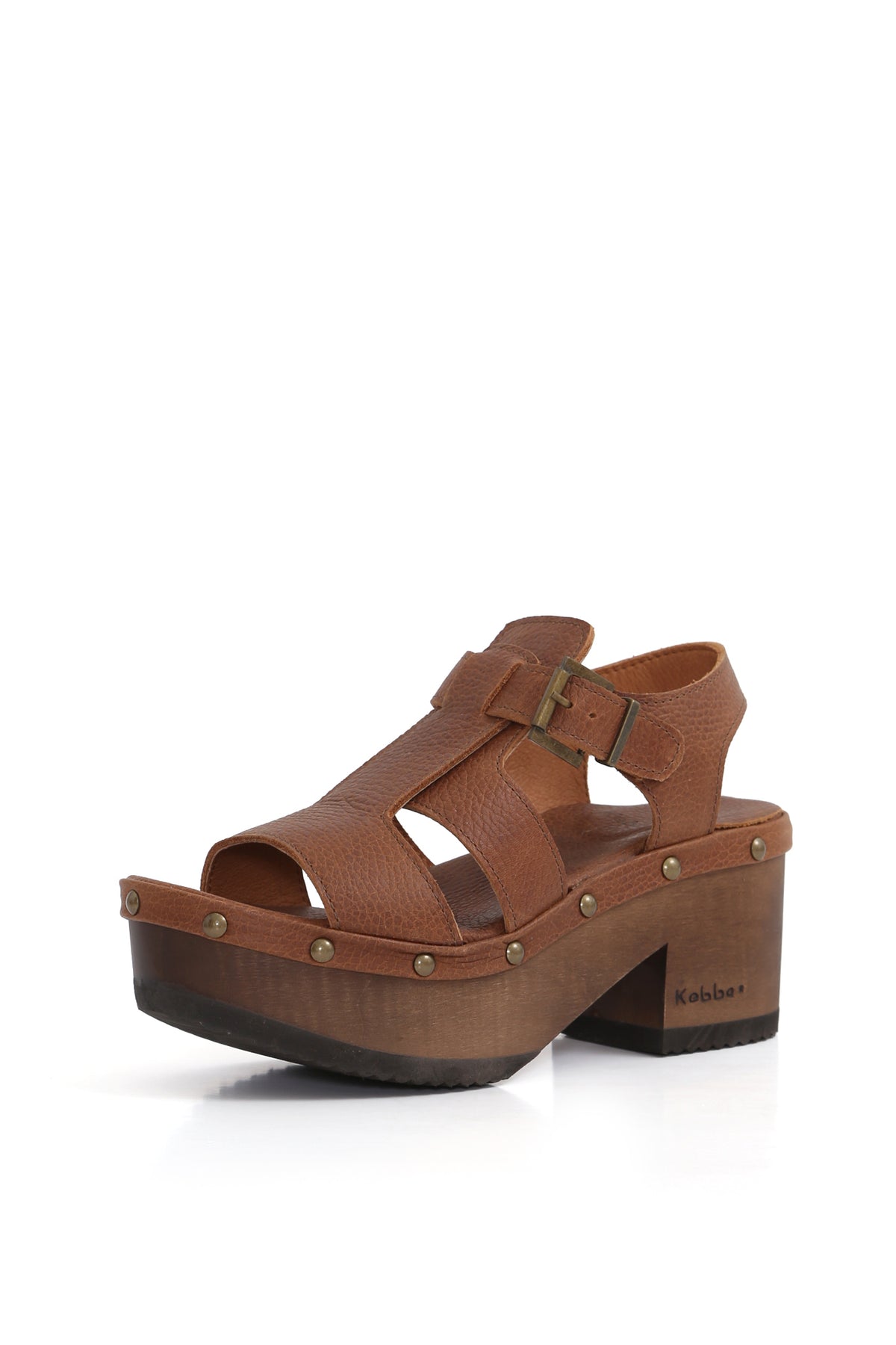 Kebba BUA Bali Texas Tostado, sandalia tipo zueco de cuero liso. Planta artesanal BUA de 8 cm en madera nativa con hebilla metálica. Imagen tres cuartos sobre fondo blanco. Piezas únicas en colecciones limitadas. Hecho a mano en Villarrica. Kebba: tradición y herencia en tus manos