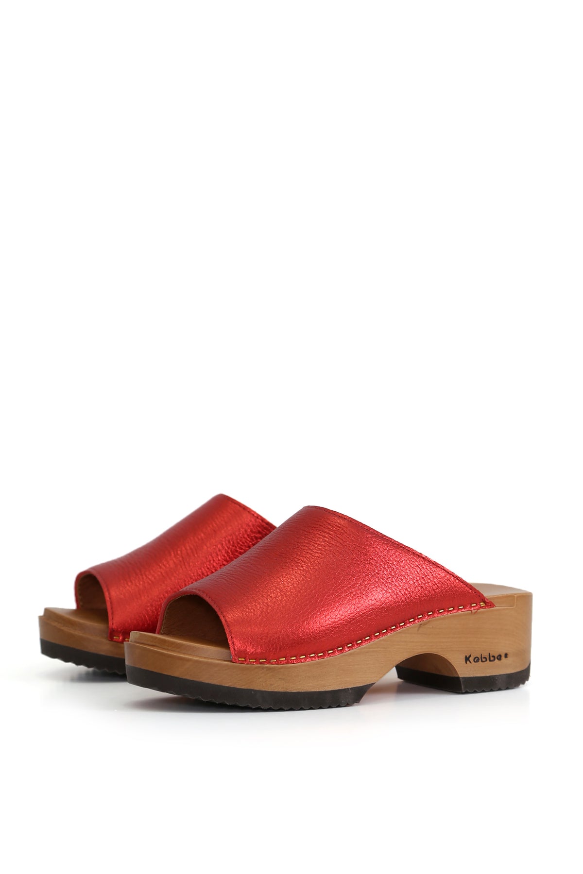 Zuecos artesanales Nicanor Floater Rojo, cuero floater liso color rojo metálico y planta de madera anatómica, vista lateral fondo blanco