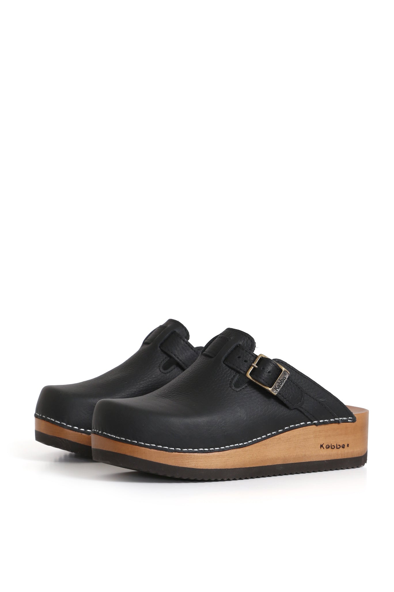 Zueco Kebba Riemen en cuero Texas negro vacuno. Planta anatómica de madera Tepa con 5 cm de altura y ajuste en el empeine. Fotografía sobre fondo blanco. Piezas únicas en colecciones limitadas. Hecho a mano en Villarrica. Kebba: tradición y herencia en tus mano