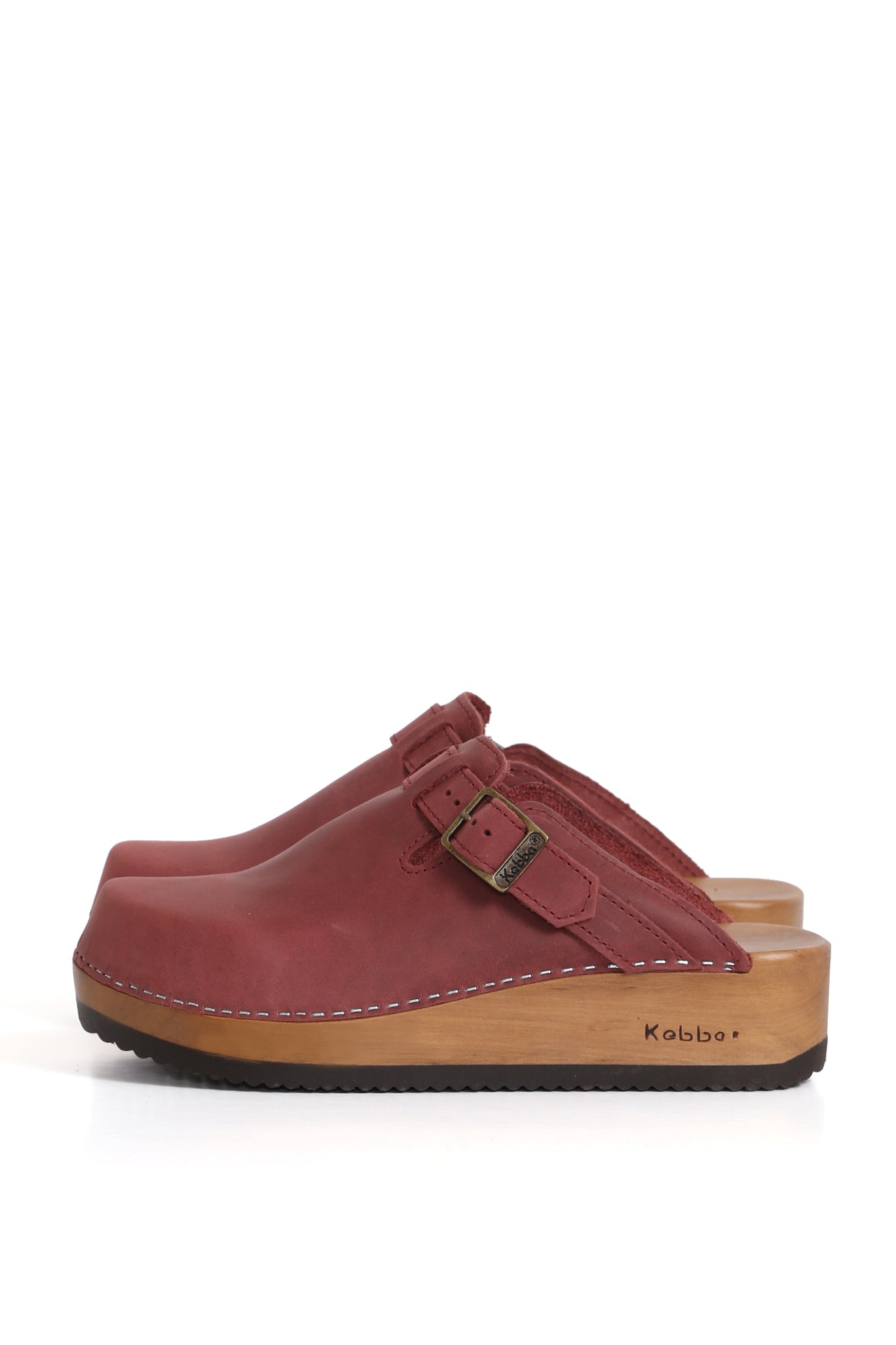 Zueco tradicional Kebba en cuero West color guinda. Planta anatómica de madera nativa con altura de 5 cm y ajuste de empeine. Fotografía sobre fondo blanco. Piezas únicas en colecciones limitadas. Hecho a mano en Villarrica. Kebba: tradición y herencia en tus manos