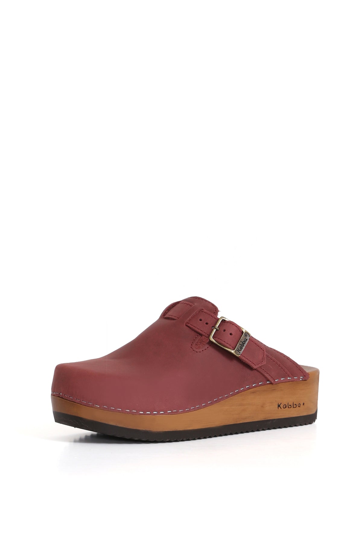 Zuecos de cuero Kebba, diseño tradicional en West guinda con ajuste en el empeine. Planta anatómica de madera nativa de 5 cm. Imagen tres cuartos sobre fondo blanco. Piezas únicas en colecciones limitadas. Hecho a mano en Villarrica. Kebba: tradición y herencia en tus manos