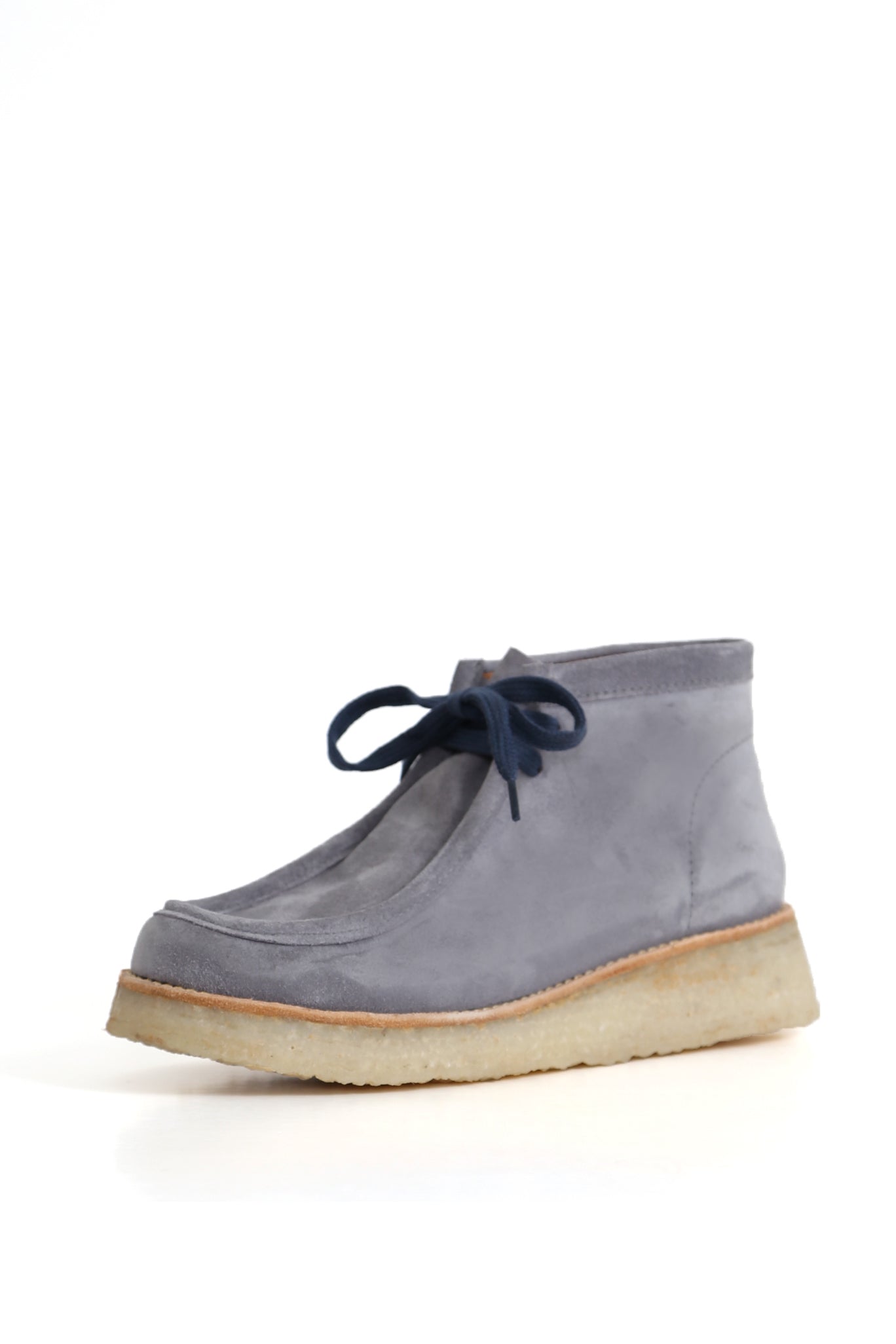 Wallabee gris perla con costura moc y cordones, suela crepé texturada, fondo blanco. zuecos artesanales