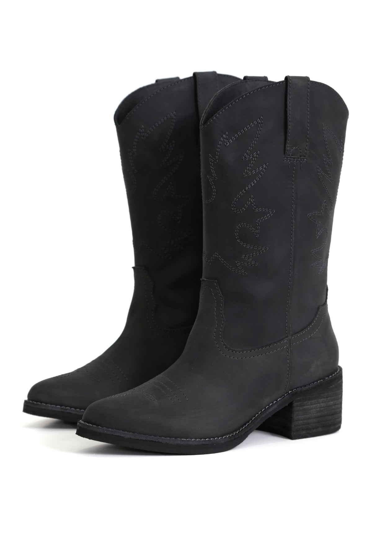 Botas artesanales Kebba Nicolasa Nacho West negras en cuero graso con diseño sin cierre y taco medio, detalle frontal fondo blanco