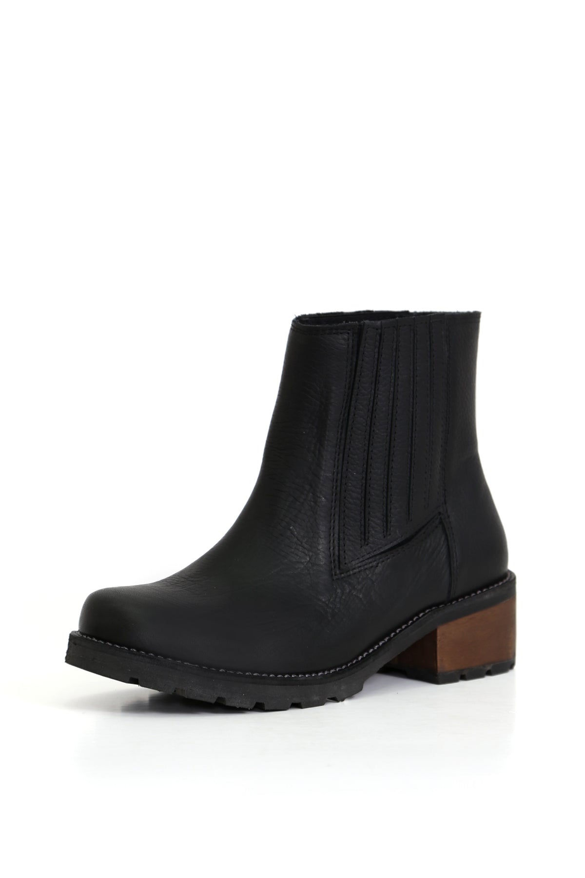 Simonita Sancho Texas Negro, botín en cuero liso con elásticos laterales. Fotografía en ángulo tres cuartos sobre fondo blanco. Planta Simonita con taco de 5 cm, forro y plantilla de cuero. Hecho a mano en Villarrica. Kebba: tradición y herencia en tus manos