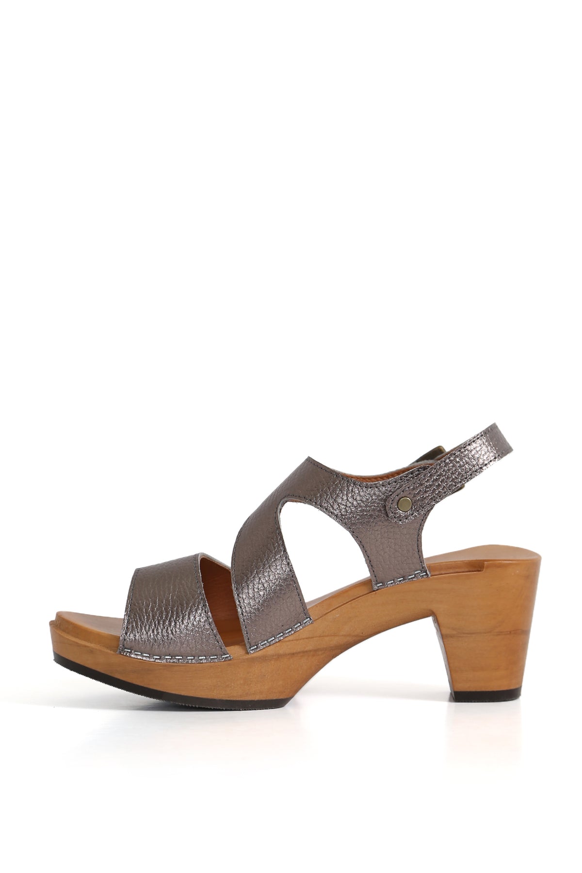 Detalle hebilla y costuras en sandalia peltre sobre base de madera, vista lateral limpia. zuecos Kebba oferta
